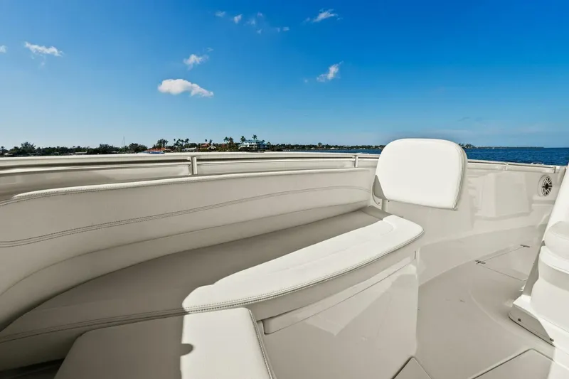 Slide: The Image of 2023 Cobia 301 Center Console boat interior with white seating, ocean view. - 12