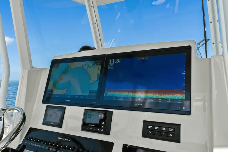 Slide: The Image of 2023 Cobia 301 Center Console dashboard with dual Garmin displays, ocean view. - 21