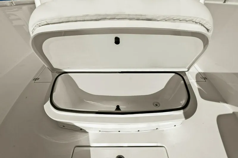 Slide: The Image of 2023 Cobia 301 Center Console storage compartment, open and empty, showcasing interior space. - 23