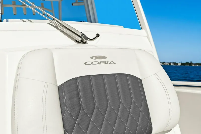 Slide: The Image of 2023 Cobia 301 Center Console seat with logo, against a blue ocean backdrop. - 24