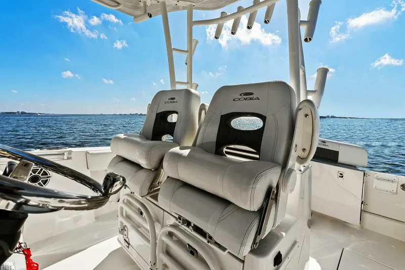 Slide: The Image of 2023 Cobia 301 Center Console boat interior with dual captain seats on open water. - 27