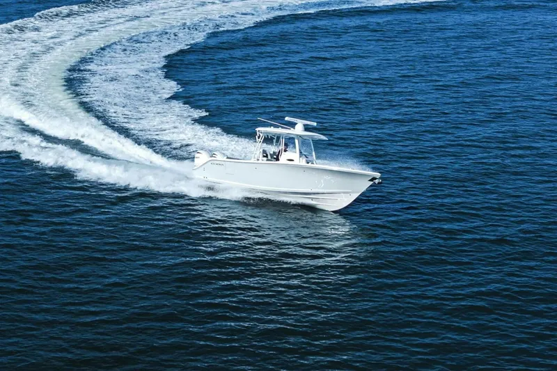 Slide: The Image of 2023 Cobia 301 Center Console boat cruising on open water. - 32