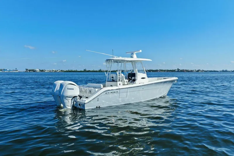 Slide: The Image of 2023 Cobia 301 Center Console boat on calm blue water. - 33