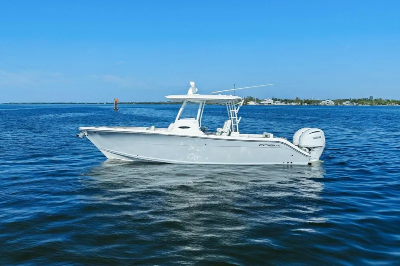 Slide: The Image of 2023 Cobia 301 Center Console boat on calm blue water. - 38