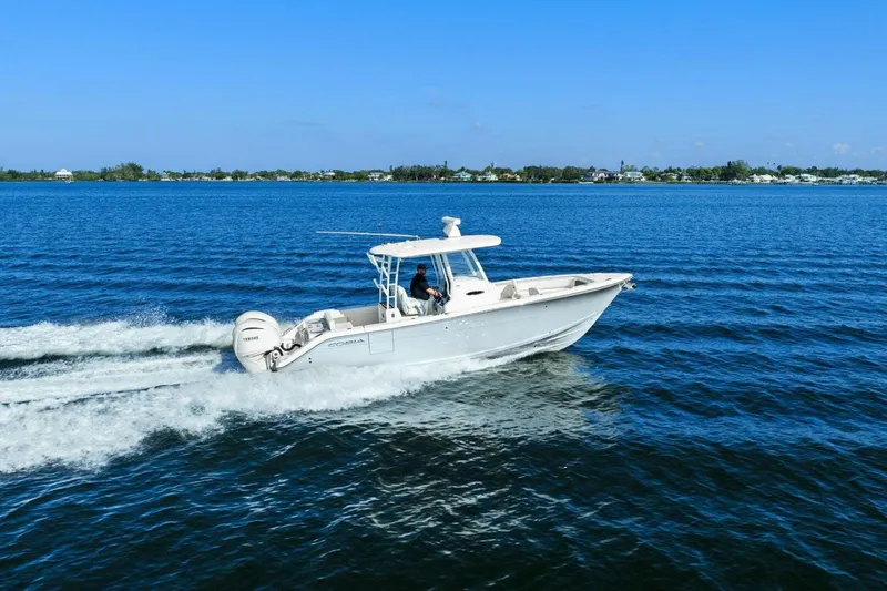 Slide: The Image of 2023 Cobia 301 Center Console boat cruising on open water. - 41