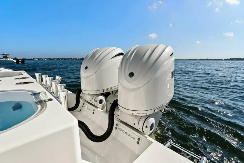 Slide: The Image of 2023 Cobia 301 Center Console boat with dual outboard engines on open water. - 6