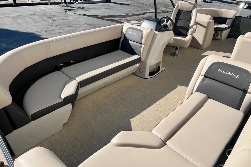 Slide: The Image of 2025 Harris Cruiser 230 pontoon boat interior with beige seating and steering console. - 10