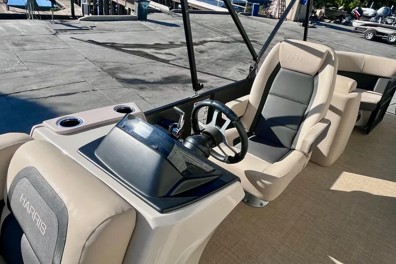 Slide: The Image of 2025 Harris Cruiser 230 boat interior with steering wheel and comfortable seating. - 12