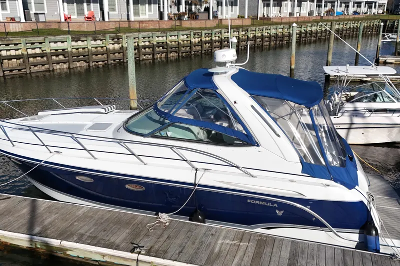 Slide: The Image of 2006 Formula 34 Performance Cruiser docked in marina, featuring sleek design and blue canopy. - 3