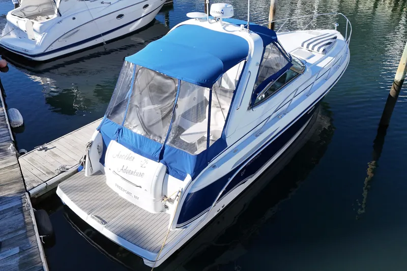 Slide: The Image of 2006 Formula 34 Performance Cruiser docked at marina, featuring blue canopy and sleek design. - 9