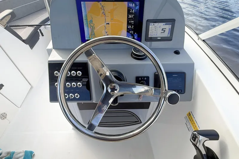 Slide: The Image of Steering console of 2025 Seapro 240 DLX boat with navigation display and controls. - 16