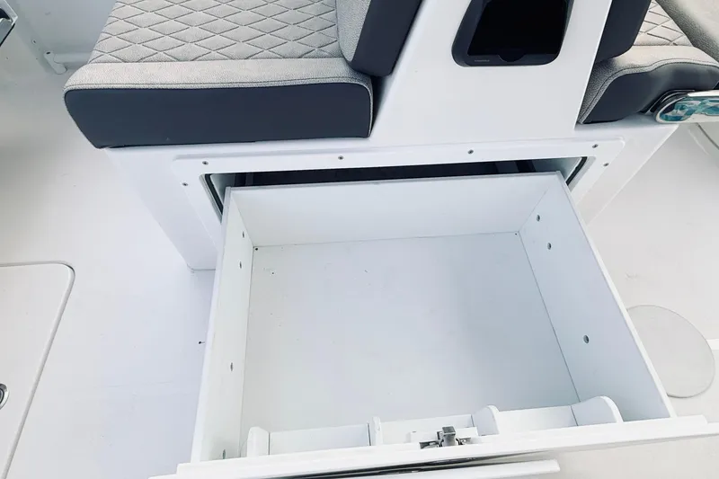 Slide: The Image of 2025 Seapro 240 DLX boat interior with open storage compartment and cushioned seating. - 21