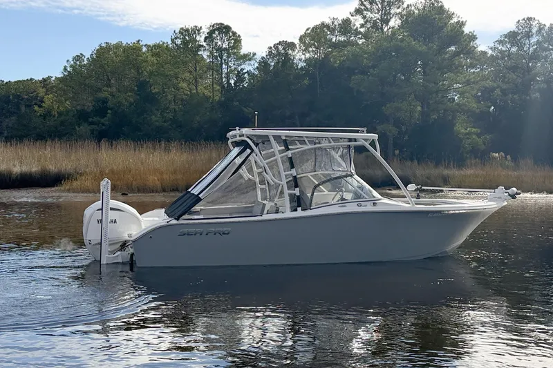 Slide: The Image of 2025 Seapro 240 DLX boat on calm water with trees in the background. - 3