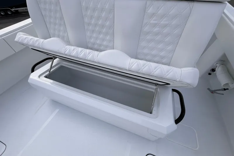 Slide: The Image of 2026 Invincible 33 Catamaran with open storage compartment and white quilted seating. - 10