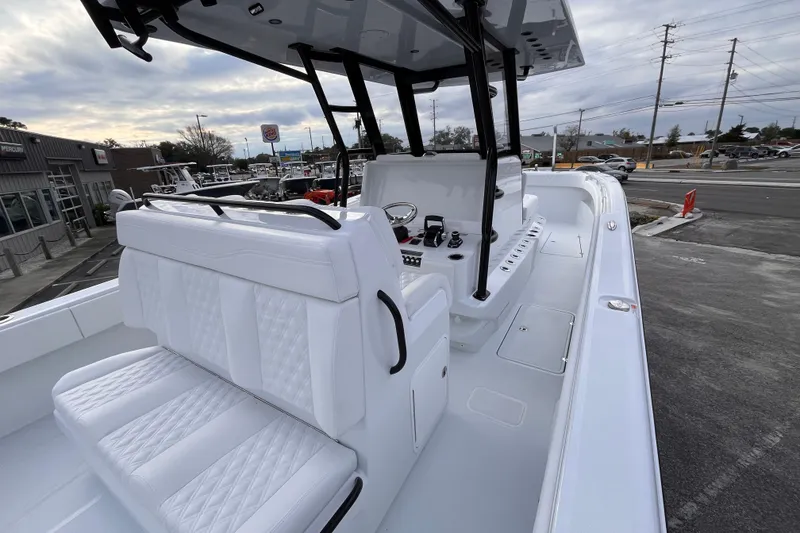 Slide: The Image of 2026 Invincible 33 Catamaran with sleek white interior and modern controls, docked outdoors. - 12