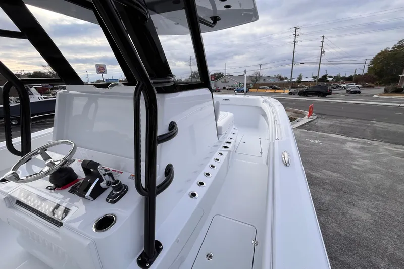 Slide: The Image of 2026 Invincible 33 Catamaran boat with sleek design and modern controls, parked outdoors. - 16