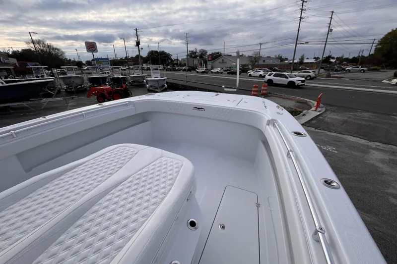 Slide: The Image of 2026 Invincible 33 Catamaran with white seating, parked near a dealership and road. - 20