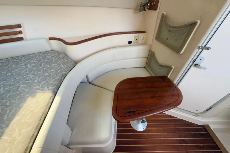 Slide: The Image of 2005 Grady-White Express 330 cabin interior with seating and wooden table. - 10
