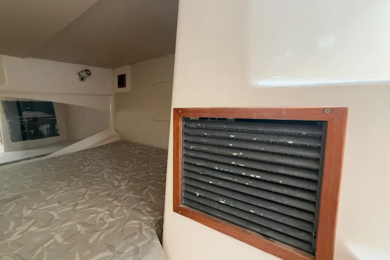 Slide: The Image of 2005 Grady-White Express 330 cabin interior with vent and patterned bedding. - 13