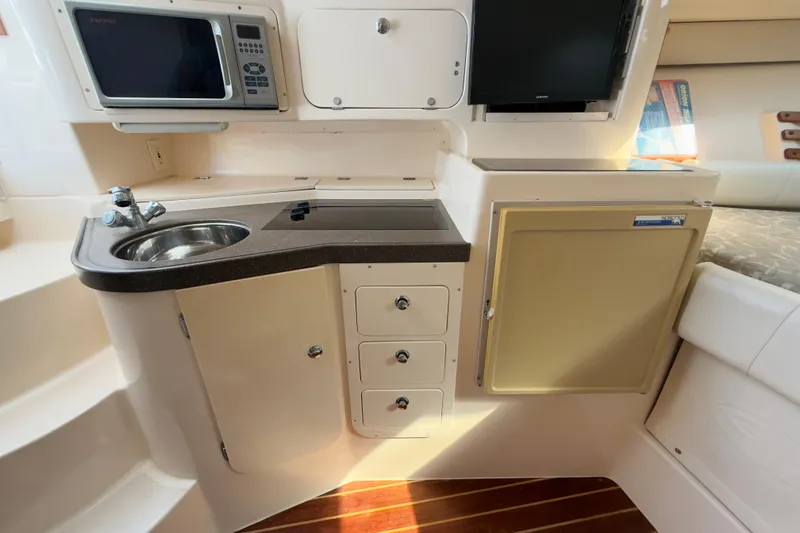 Slide: The Image of 2005 Grady-White Express 330 boat interior with kitchenette, sink, and storage cabinets. - 17