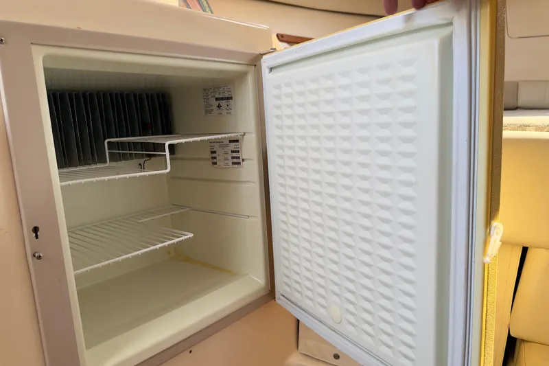 Slide: The Image of Open refrigerator inside 2005 Grady-White Express 330 boat, showing empty shelves. - 18