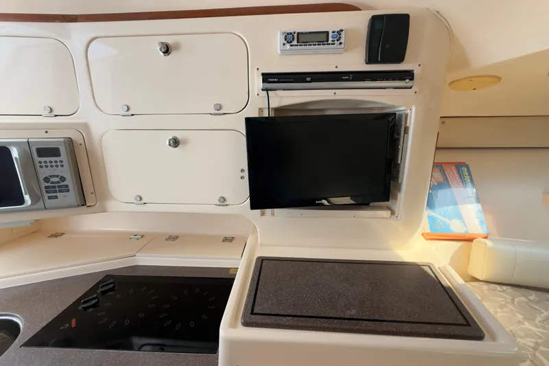 Slide: The Image of 2005 Grady-White Express 330 interior with kitchen appliances and storage cabinets. - 19