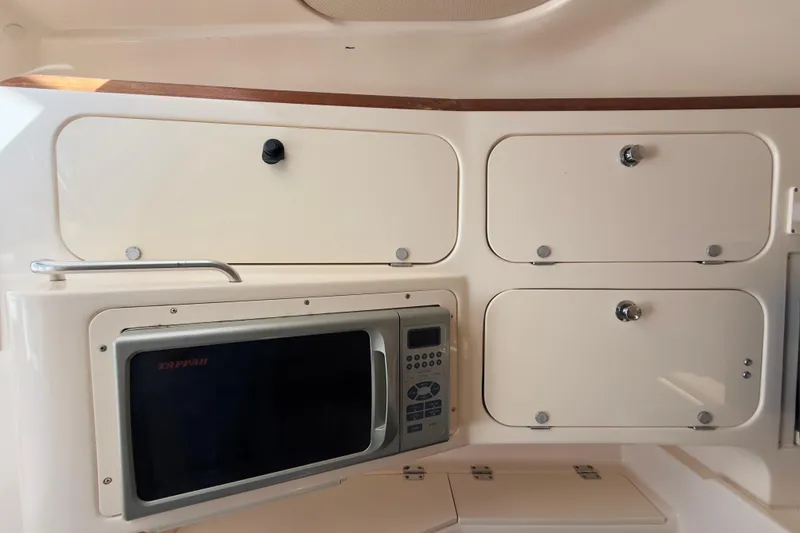 Slide: The Image of 2005 Grady-White Express 330 interior with microwave and storage cabinets. - 23