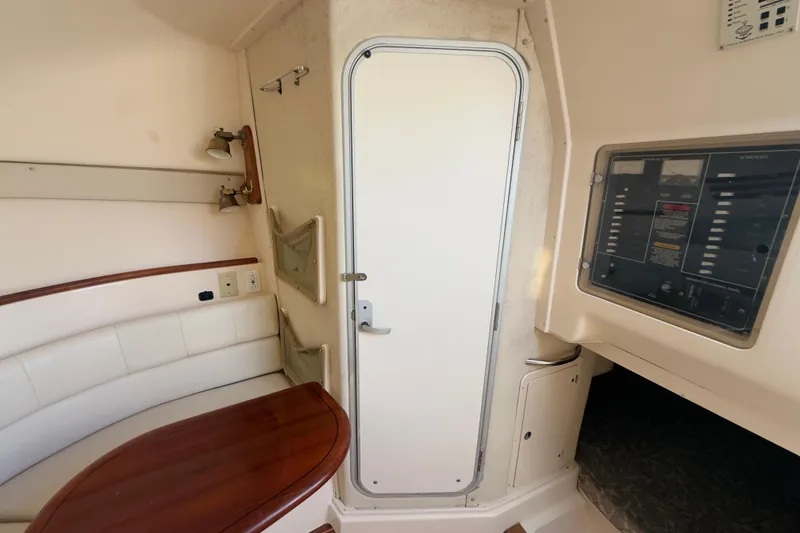 Slide: The Image of 2005 Grady-White Express 330 cabin interior with seating, control panel, and door. - 24