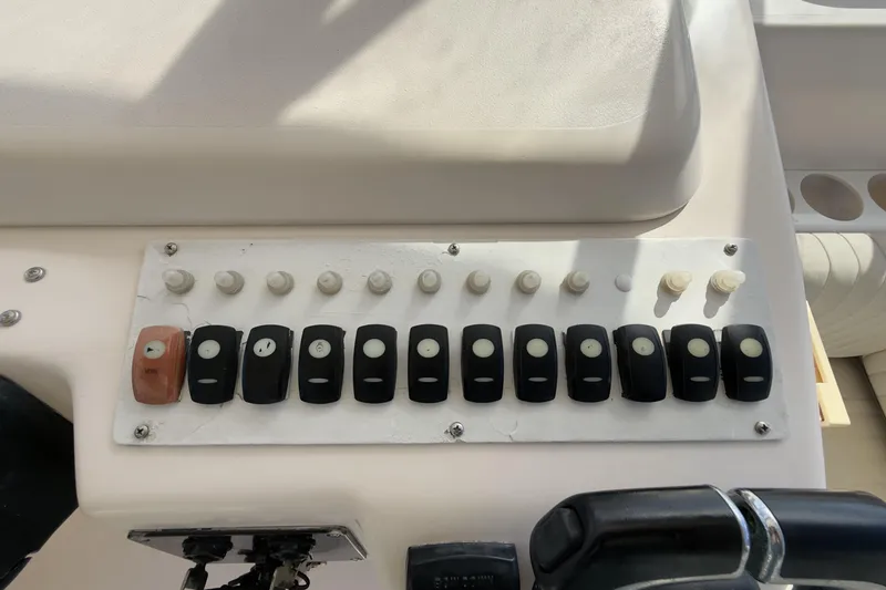 Slide: The Image of Control panel of a 2005 Grady-White Express 330 boat with switches and knobs. - 36