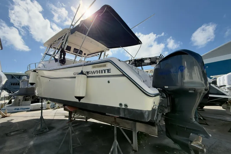 Slide: The Image of 2005 Grady-White Express 330 boat on stands, with outboard motors, under a clear sky. - 61