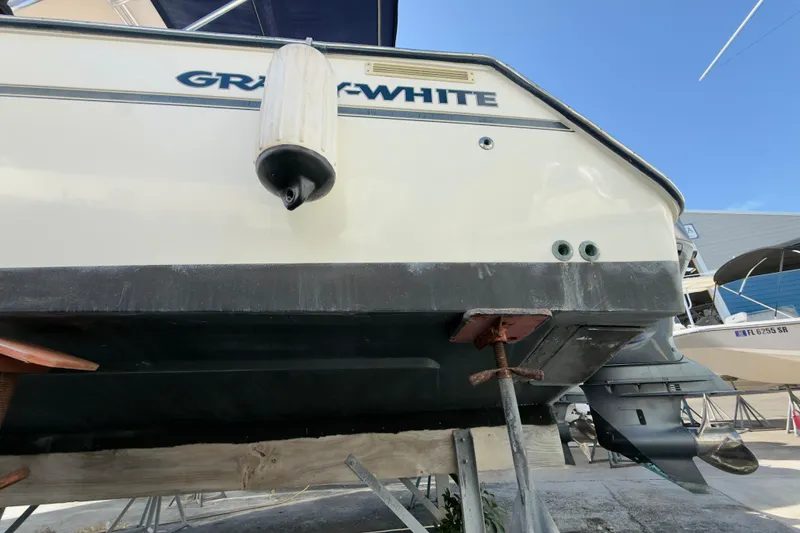 Slide: The Image of 2005 Grady-White Express 330 boat on dry dock, showing hull and outboard motor. - 64