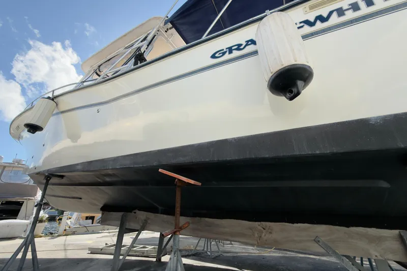 Slide: The Image of 2005 Grady-White Express 330 boat on stands, viewed from below, with clear sky background. - 65
