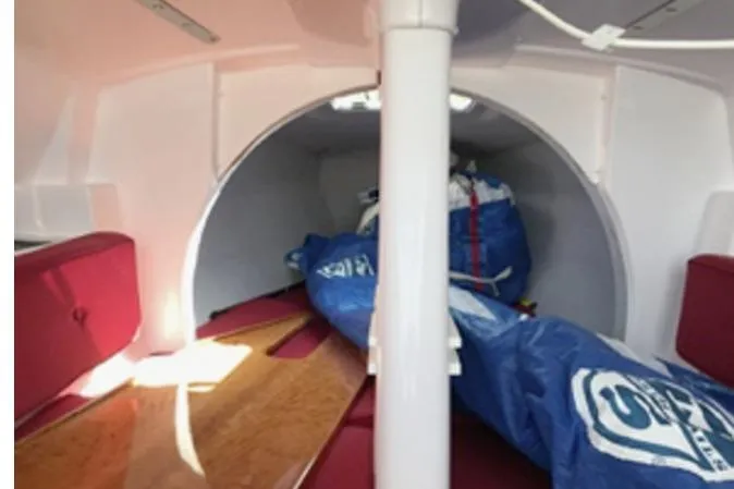 Slide: The Image of Interior of 2015 Corsair Dash 750MKII sailboat with red seating and blue sail bags. - 10