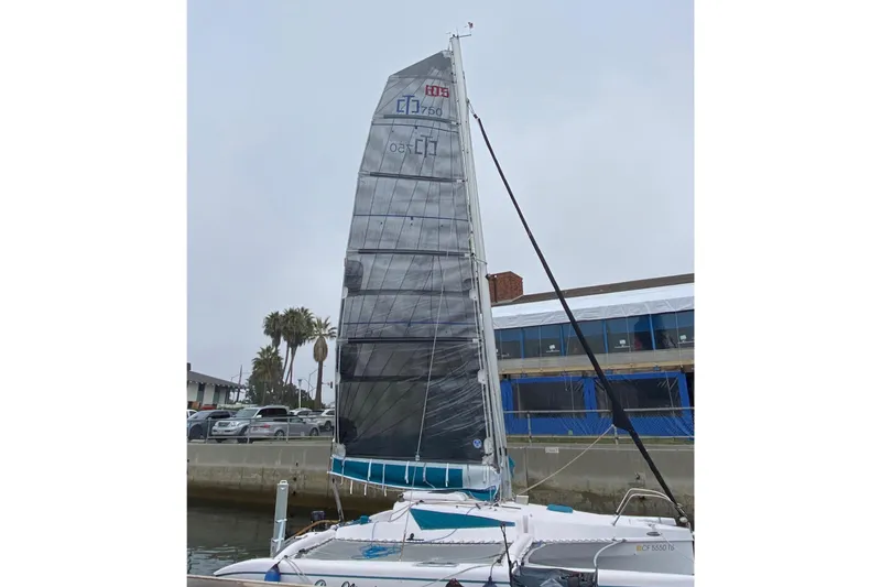 Slide: The Image of 2015 Corsair Dash 750MKII sailboat docked near a building and palm trees. - 3