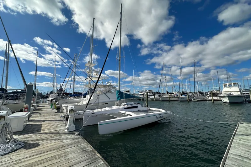 Slide: The Image of Corsair Dash 750MKII 2015 sailboat docked at a marina under a blue sky. - 4