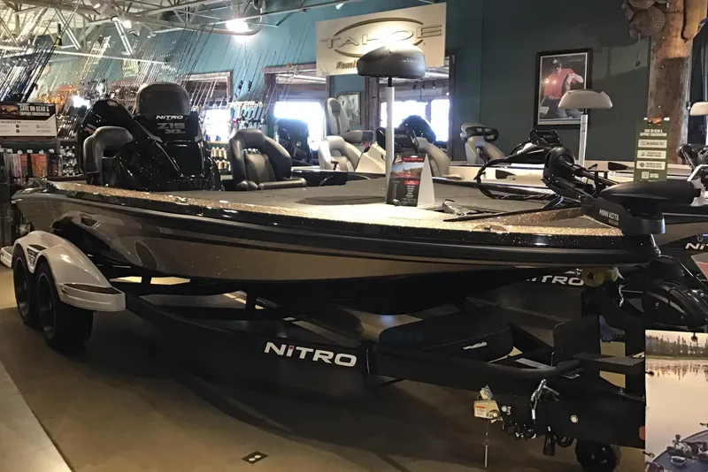 The Image of 2026 Nitro Z19 XL boat displayed in a showroom with fishing gear. - 0