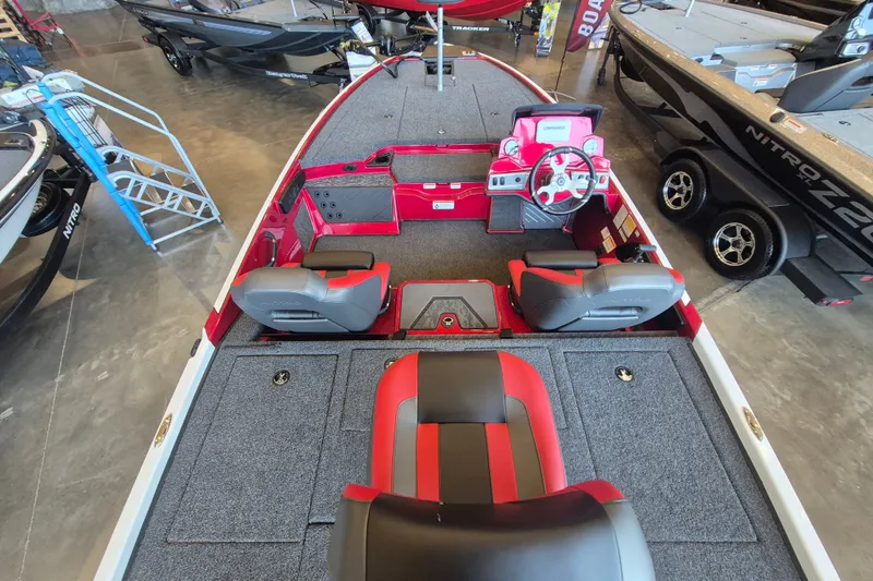 Slide: The Image of 2026 Nitro Z19 XL boat interior with red and gray seating, steering wheel, and carpeted deck. - 7