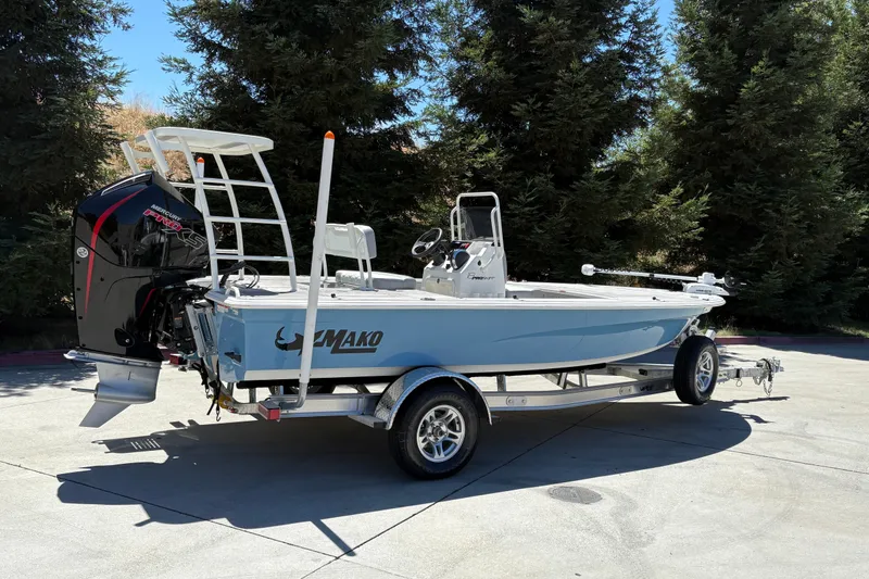 Slide: The Image of 2026 Mako 18 Pro Skiff boat on trailer, featuring Mercury engine, parked outdoors. - 2