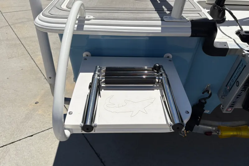 Slide: The Image of 2026 Mako 18 Pro Skiff boat ladder with shark design on a sunny day. - 22