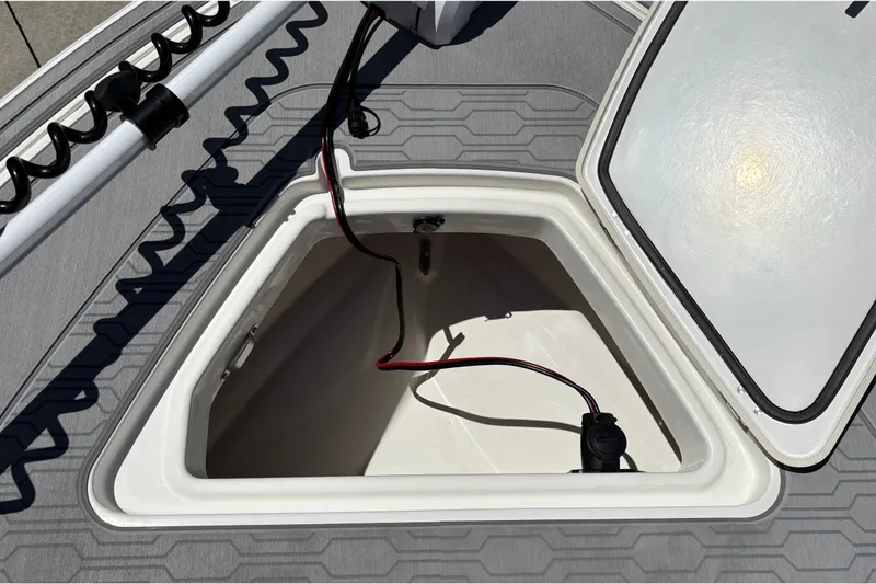 Slide: The Image of Open storage compartment on 2026 Mako 18 Pro Skiff boat, featuring wiring and textured flooring. - 28