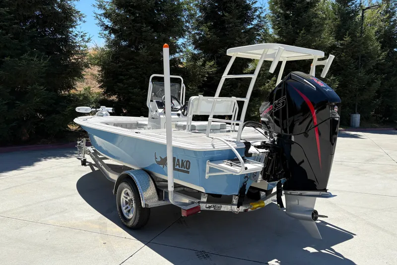 Slide: The Image of 2026 Mako 18 Pro Skiff boat with outboard motor on trailer, parked outdoors. - 10