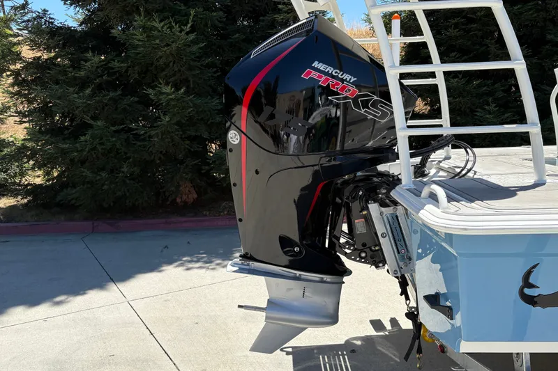Slide: The Image of Outboard motor on a 2026 Mako 18 Pro Skiff, parked outdoors. - 12