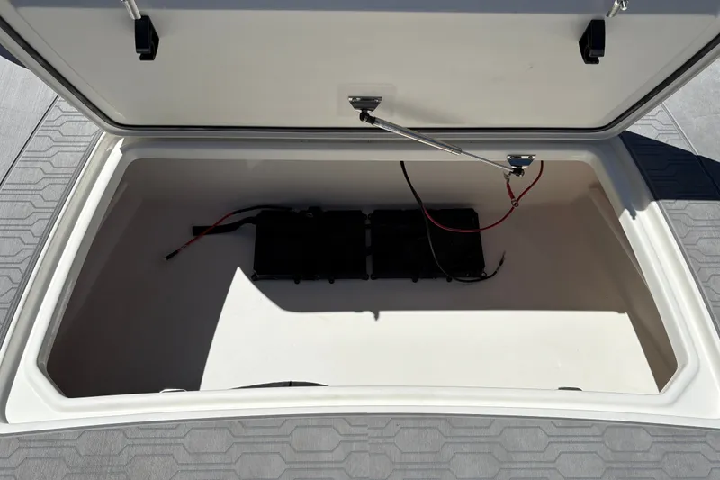 Slide: The Image of Open storage compartment in 2026 Mako 18 Pro Skiff boat, featuring battery and wiring. - 25