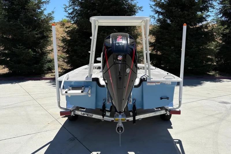 Slide: The Image of 2026 Mako 18 Pro Skiff with powerful outboard motor on trailer, parked outdoors. - 11