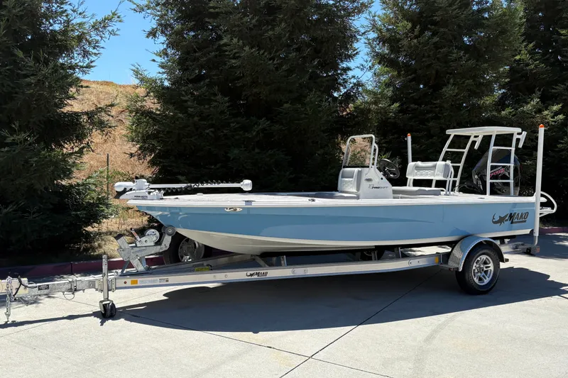 Slide: The Image of 2026 Mako 18 Pro Skiff boat on trailer, parked outdoors near trees. - 4