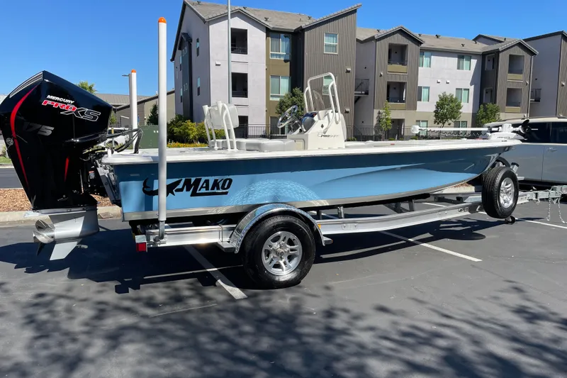 Slide: The Image of 2026 Mako 18 Pro Skiff boat with Mercury Pro XS engine on trailer in parking lot. - 1