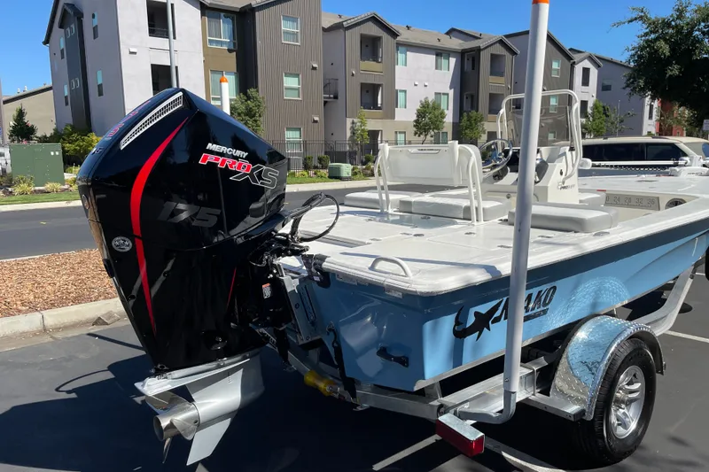 Slide: The Image of 2026 Mako 18 Pro Skiff boat with Mercury Pro XS 175 engine in a parking lot. - 3