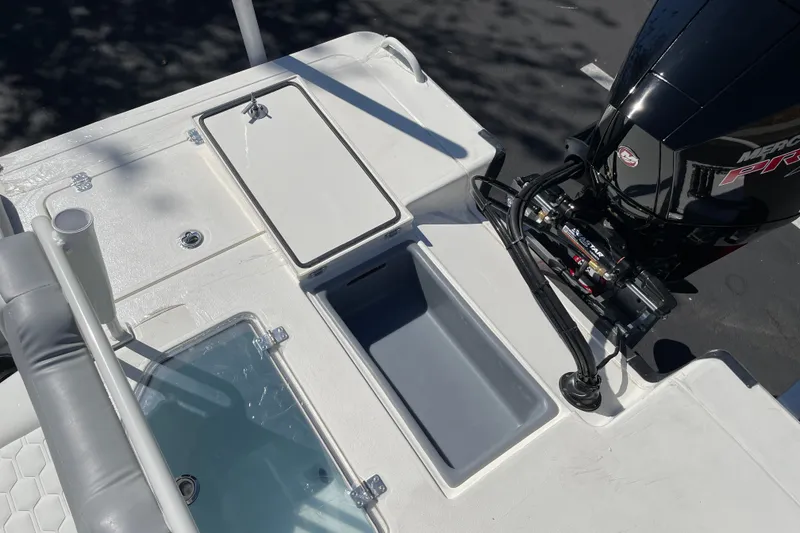 Slide: The Image of 2026 Mako 18 Pro Skiff boat deck with storage compartments and outboard motor. - 11