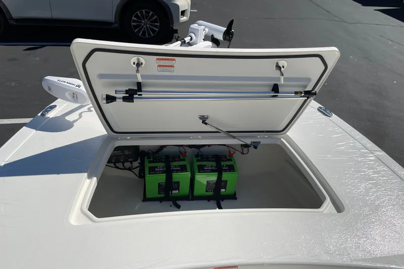 Slide: The Image of Open storage compartment of 2026 Mako 18 Pro Skiff with green batteries inside. - 20