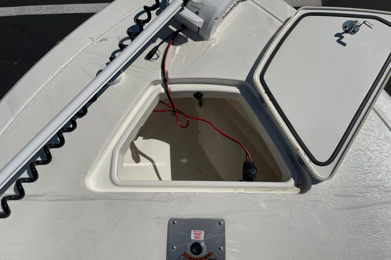Slide: The Image of Open storage compartment on 2026 Mako 18 Pro Skiff boat, showing wiring and hatch. - 22